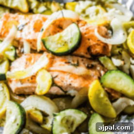 Garlic Herb Salmon and Zucchini grilled in foil with onions, showcasing the rich flavors.