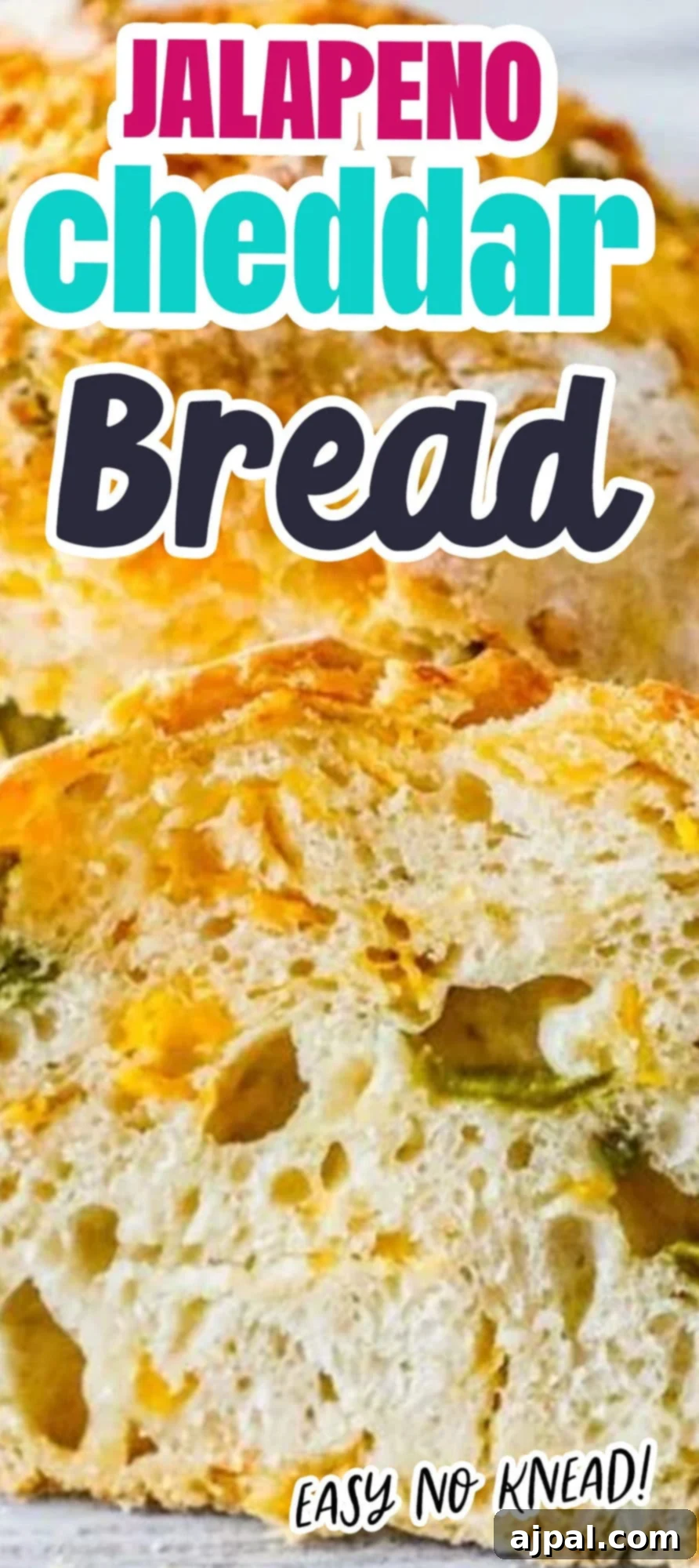 A freshly baked loaf of no-knead jalapeño cheddar bread, sliced in half to reveal its cheesy, spicy interior.