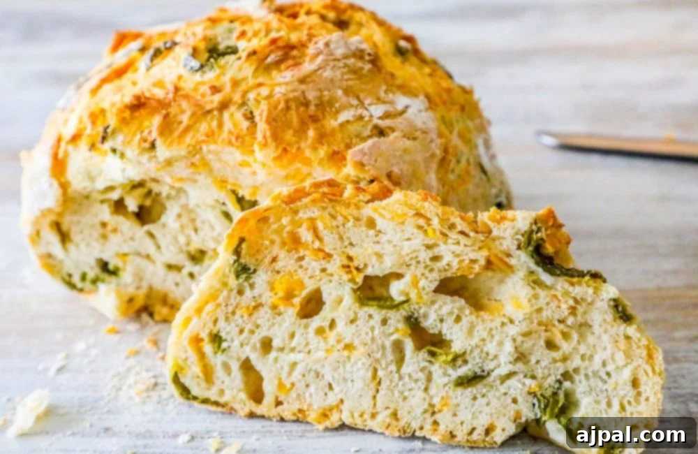 A beautiful cross-section of homemade jalapeño cheddar bread, showing its open crumb and flavorful additions.