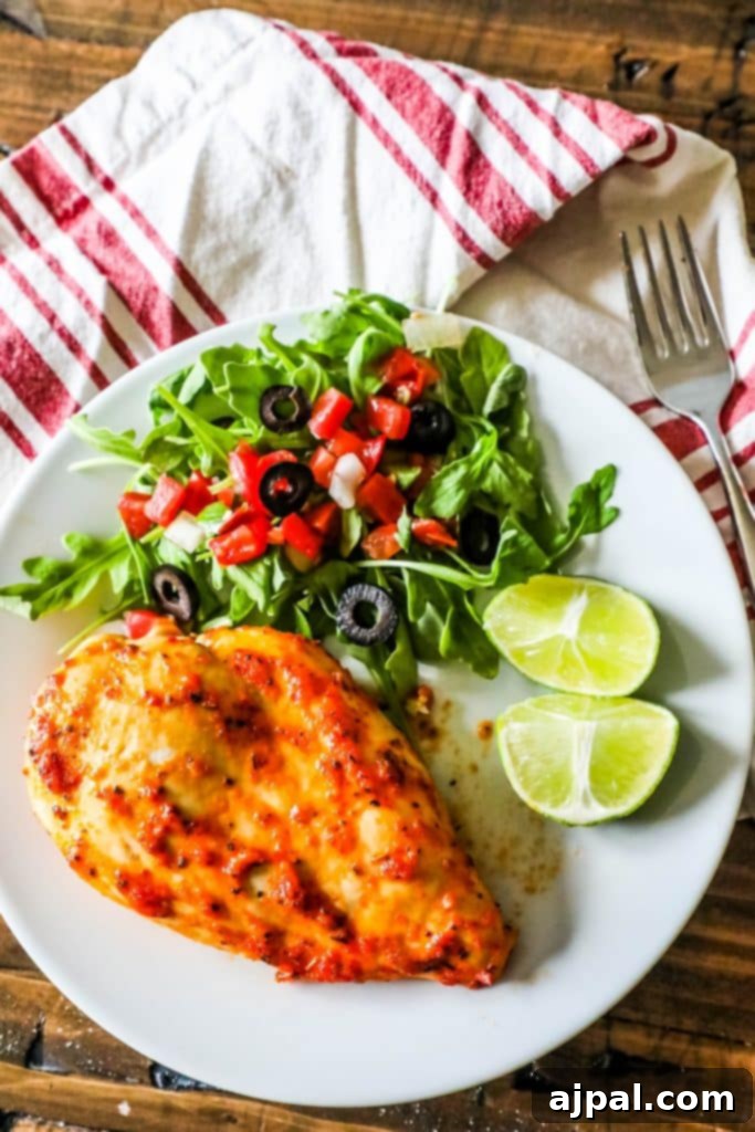 Pimento Infused Roast Chicken 5 Tender oven-roasted pimento chicken with a fresh, crisp salad and lime wedges on a white plate.