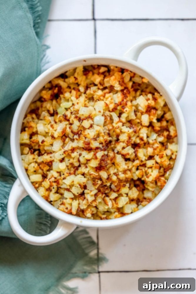 browned cauliflower rice in a white bowl.