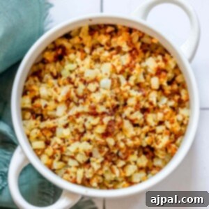 Easy keto cauliflower rice recipe served in a white bowl on a tile floor.