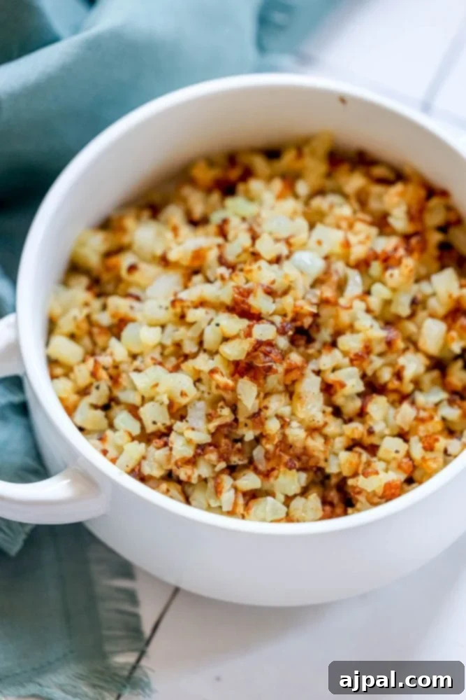 browned cauliflower rice in a white bowl.