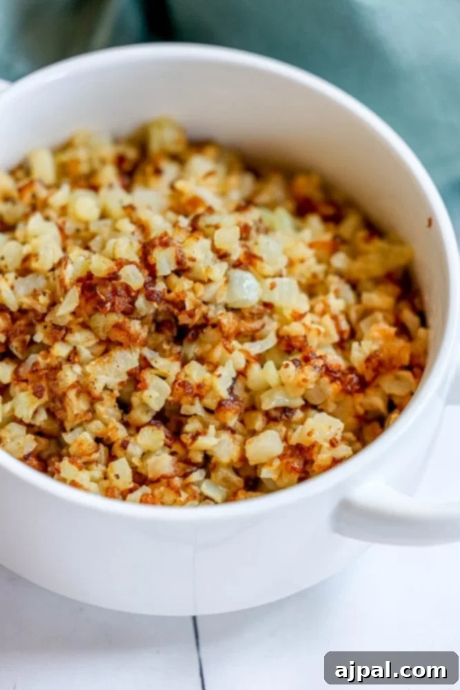 browned cauliflower rice in a white bowl.
