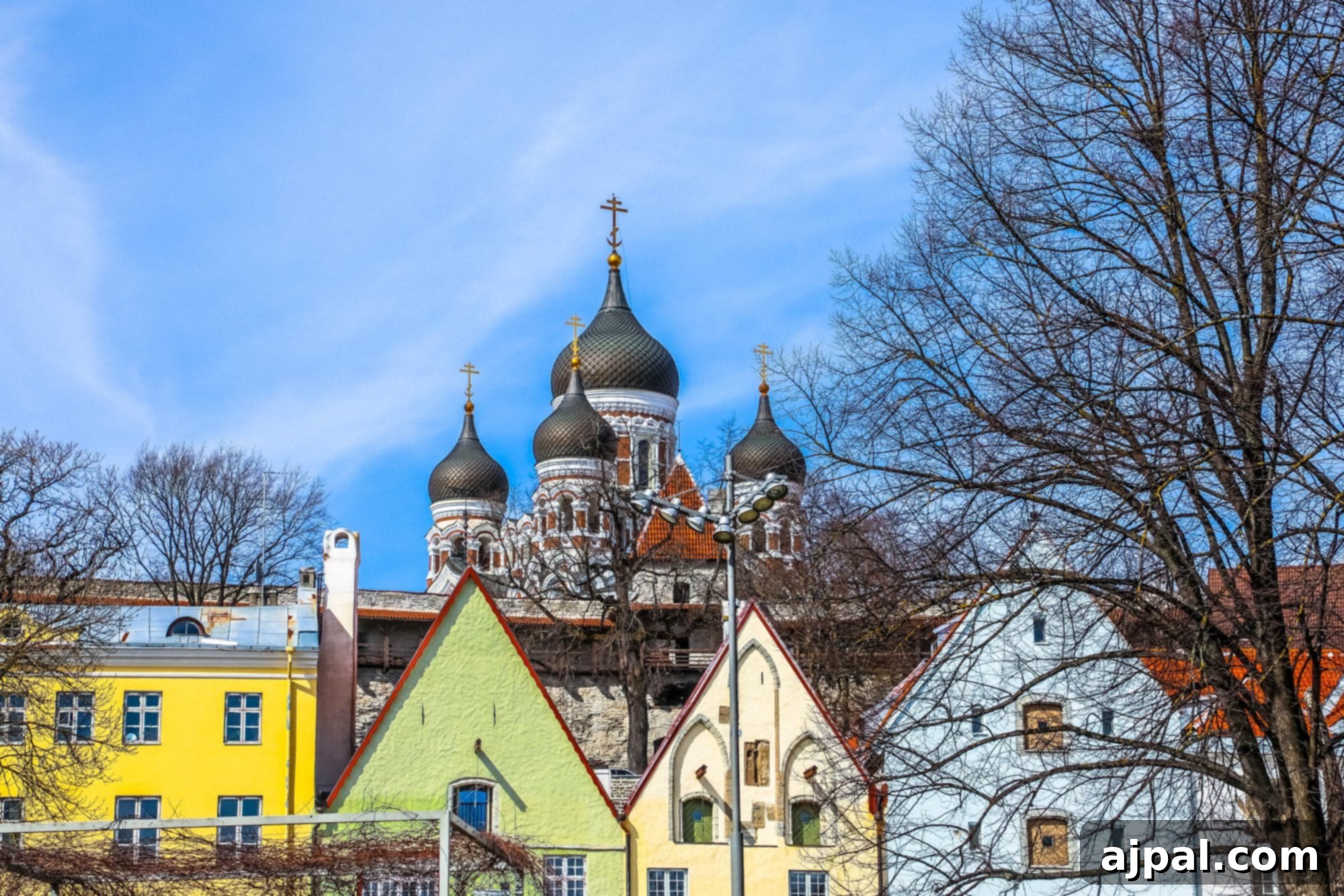 A picturesque view of colorful buildings in Tallinn's Old Town, with the distinctive Alexander Nevsky Cathedral visible in the background, adding to the city's charm.