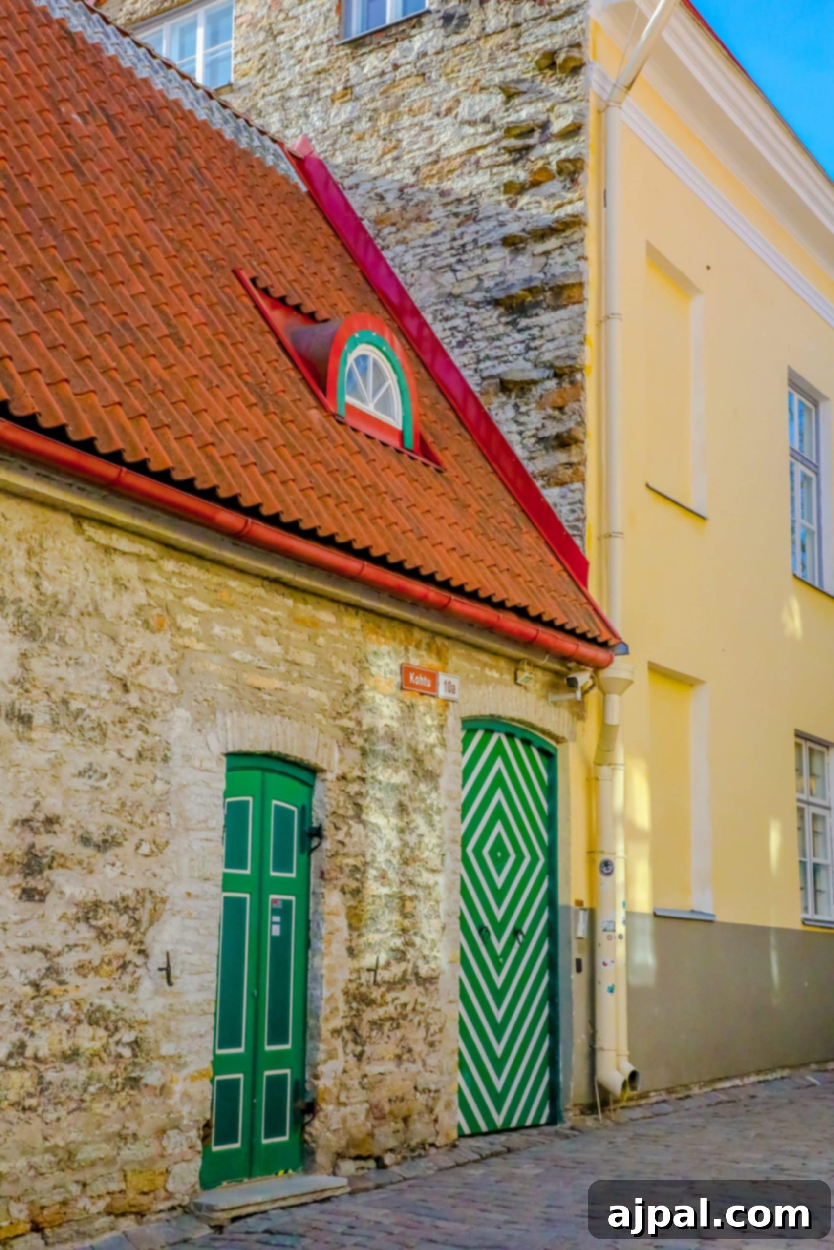 A charming brick building in Tallinn, Estonia, featuring a distinctive green door, blending historic architecture with vibrant details.