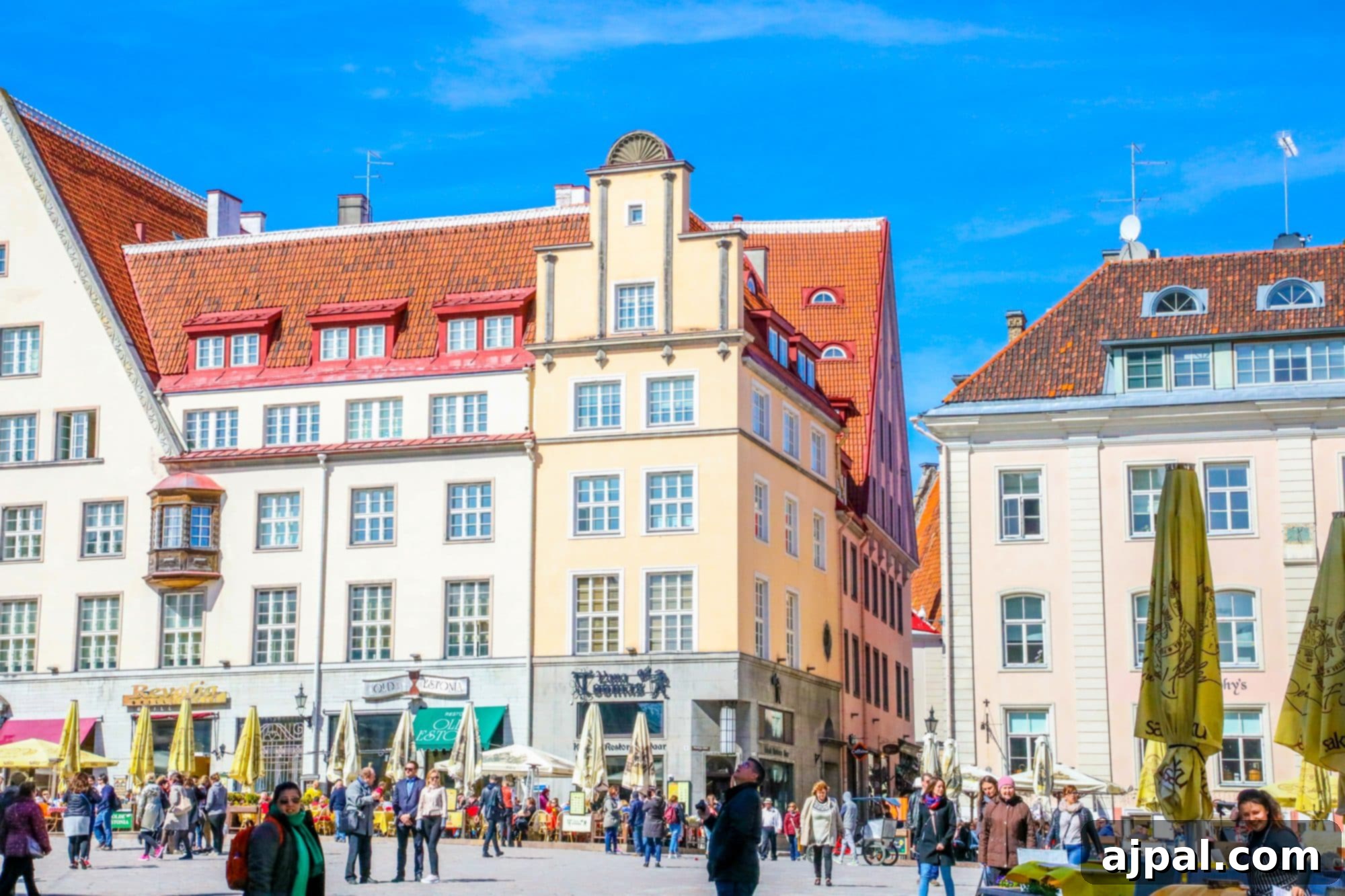 A bustling square in Tallinn, Estonia, filled with historic buildings, vibrant crowds, and a lively atmosphere.