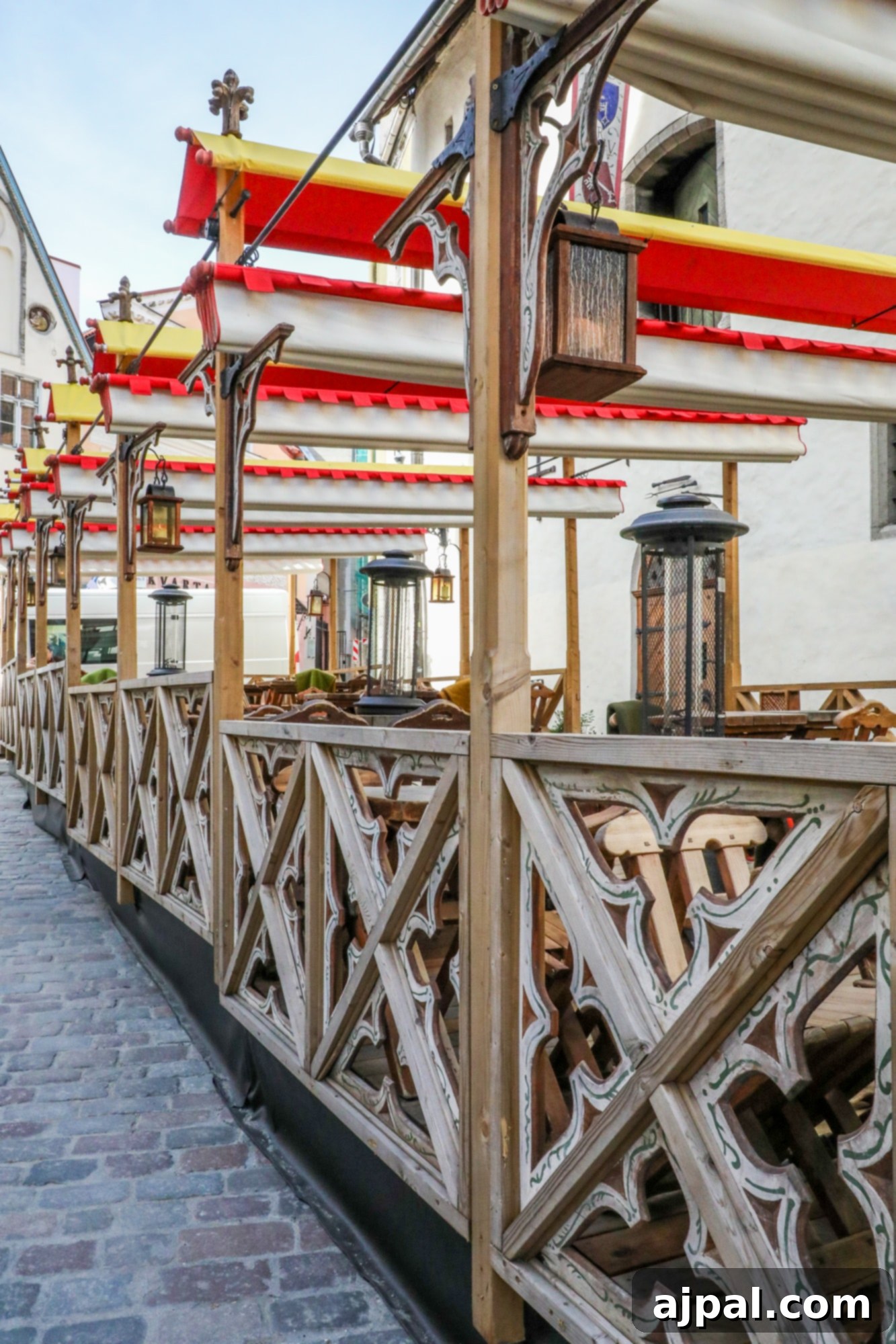 A charming medieval-themed restaurant in Tallinn, Estonia, with outdoor seating on a cobblestone street, inviting passersby to dine.