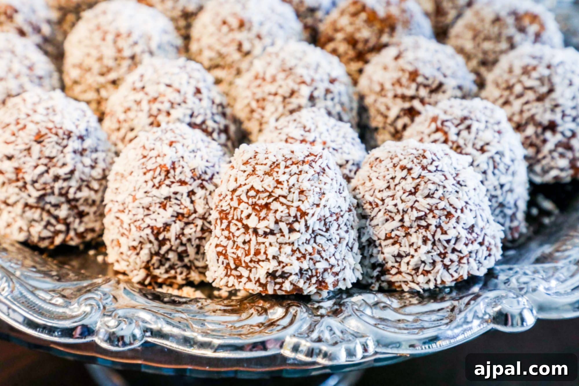 A selection of traditional Estonian cakes and pastries, including delicate coconut balls, elegantly displayed on a silver platter, ready to be enjoyed.