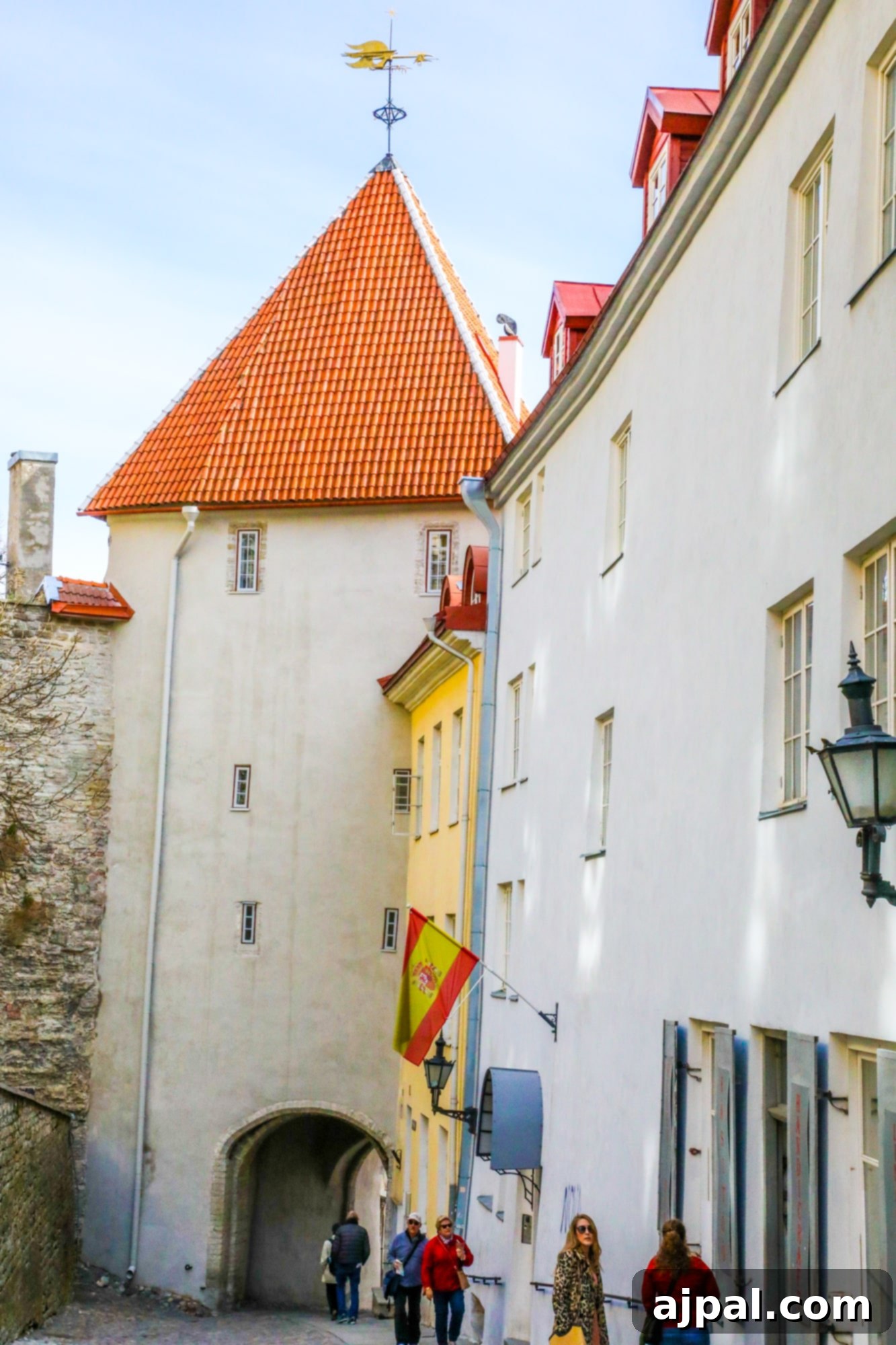 A well-preserved medieval city wall tower in Tallinn, Estonia, featuring a white building with a distinctive red roof, showcasing the city's ancient defenses.