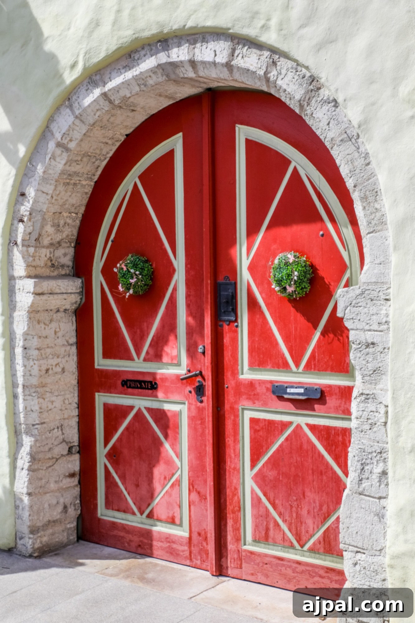 A bold red door with a unique diamond pattern, enhancing the charm of a historic building in Tallinn, Estonia.