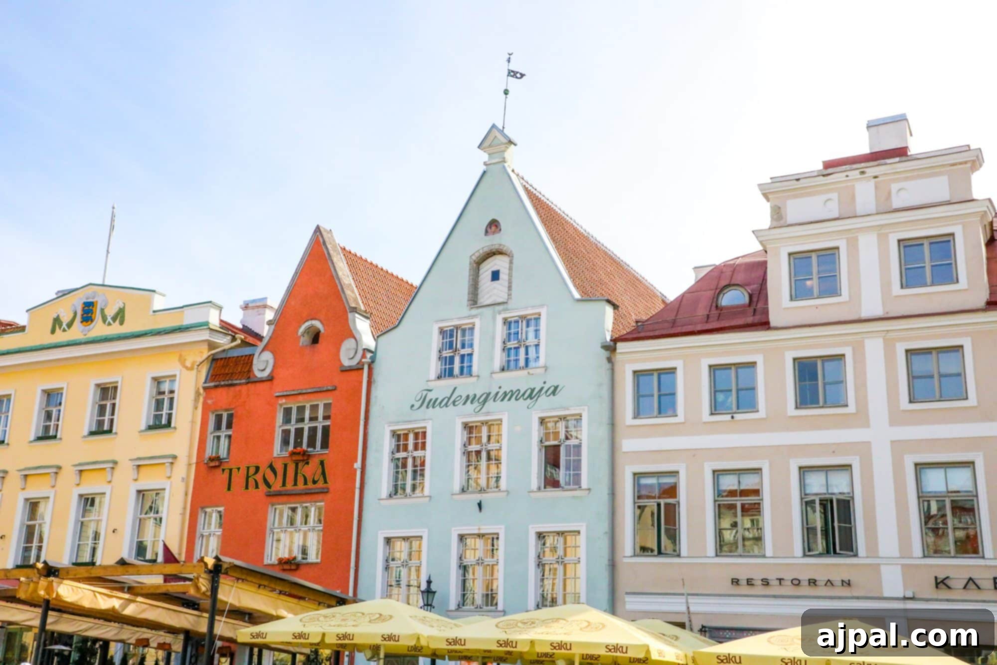 A vibrant row of colorful buildings lining the main square of Tallinn, Estonia's Old Town, with inviting cafes and shops.