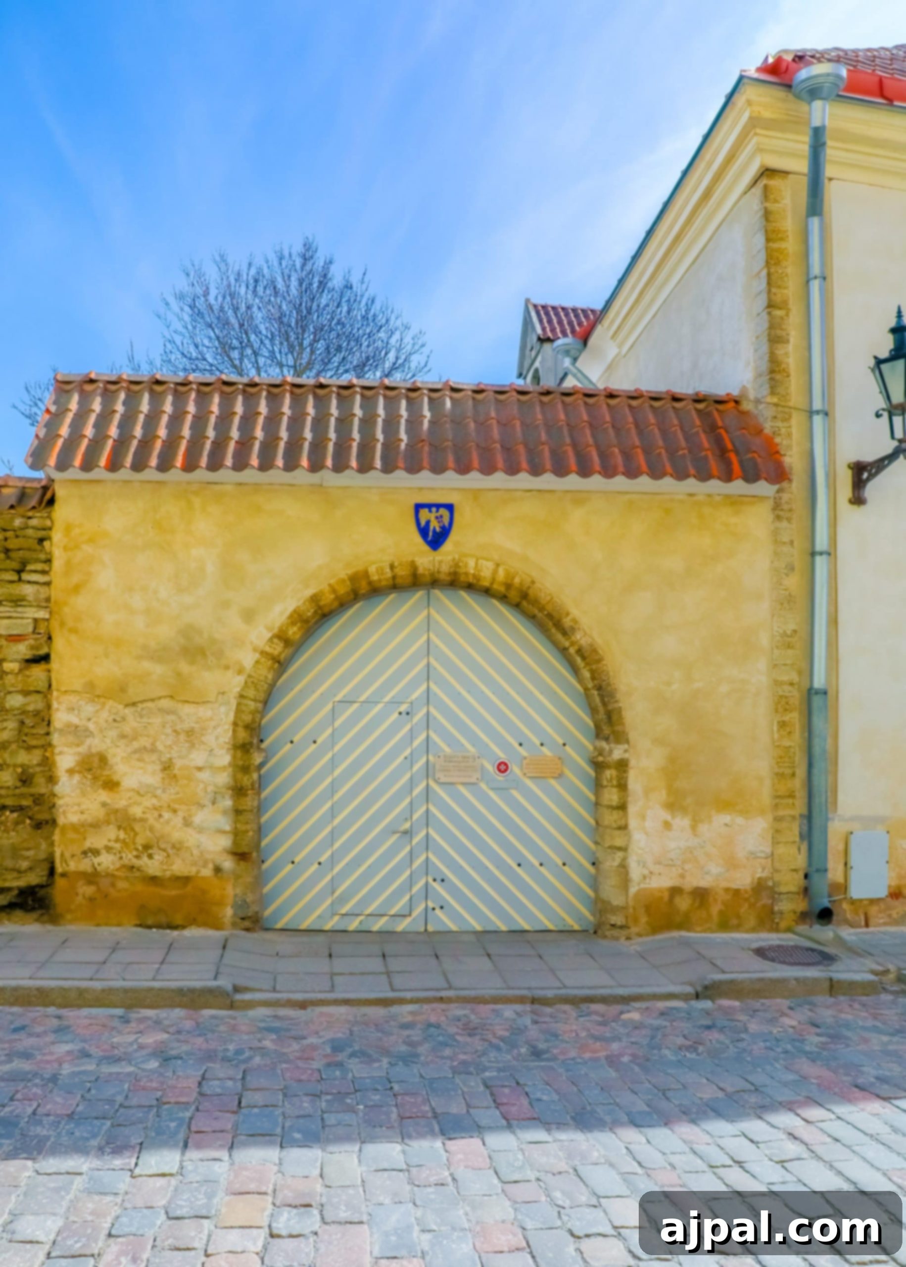 A charming historic stone building in Tallinn, Estonia, featuring an intricately designed wooden door, beckoning travelers to explore its secrets.