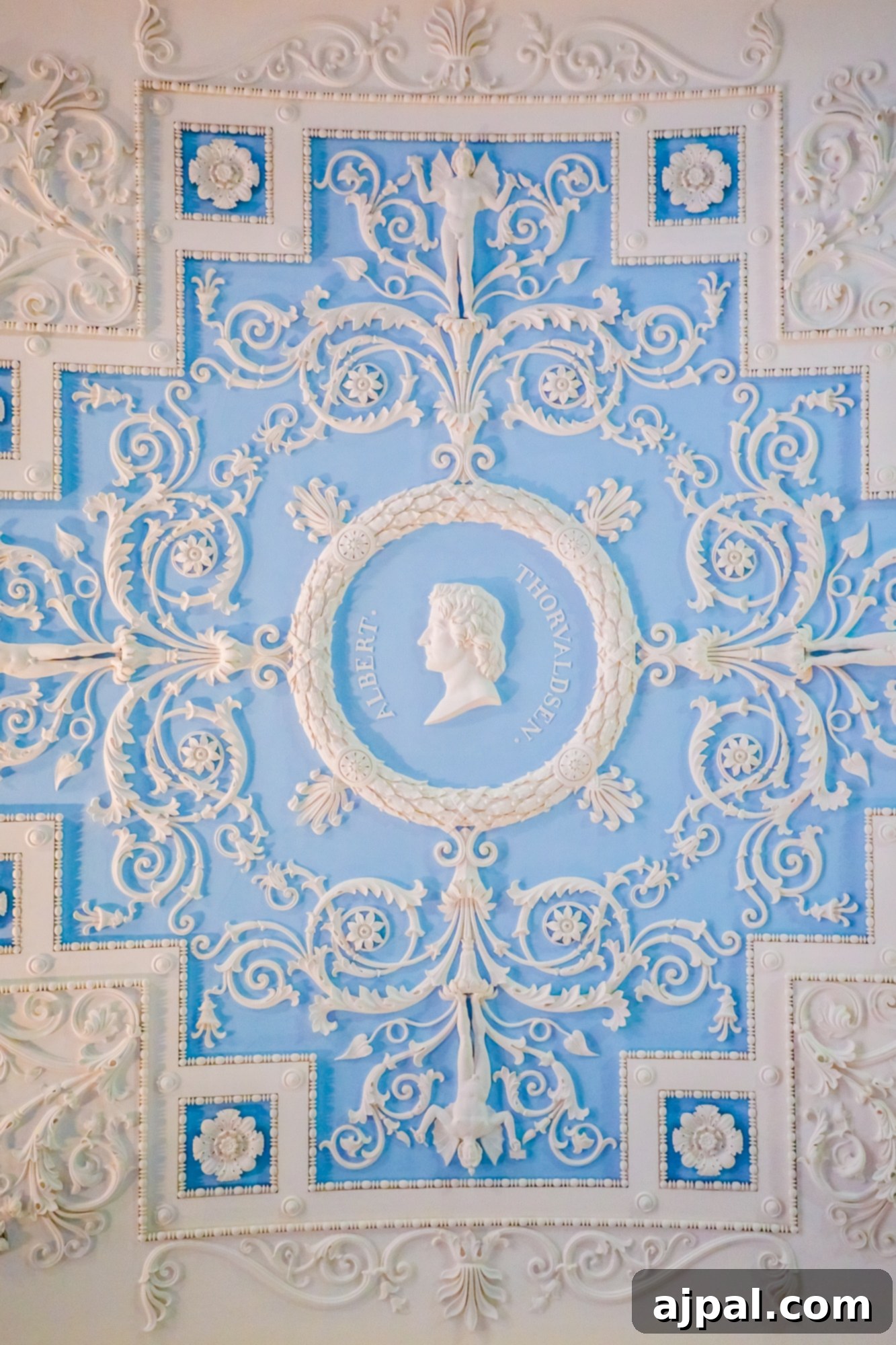 An exquisitely ornate ceiling in a serene blue room, a highlight of the Ultimate Saint Petersburg Shore Excursion.