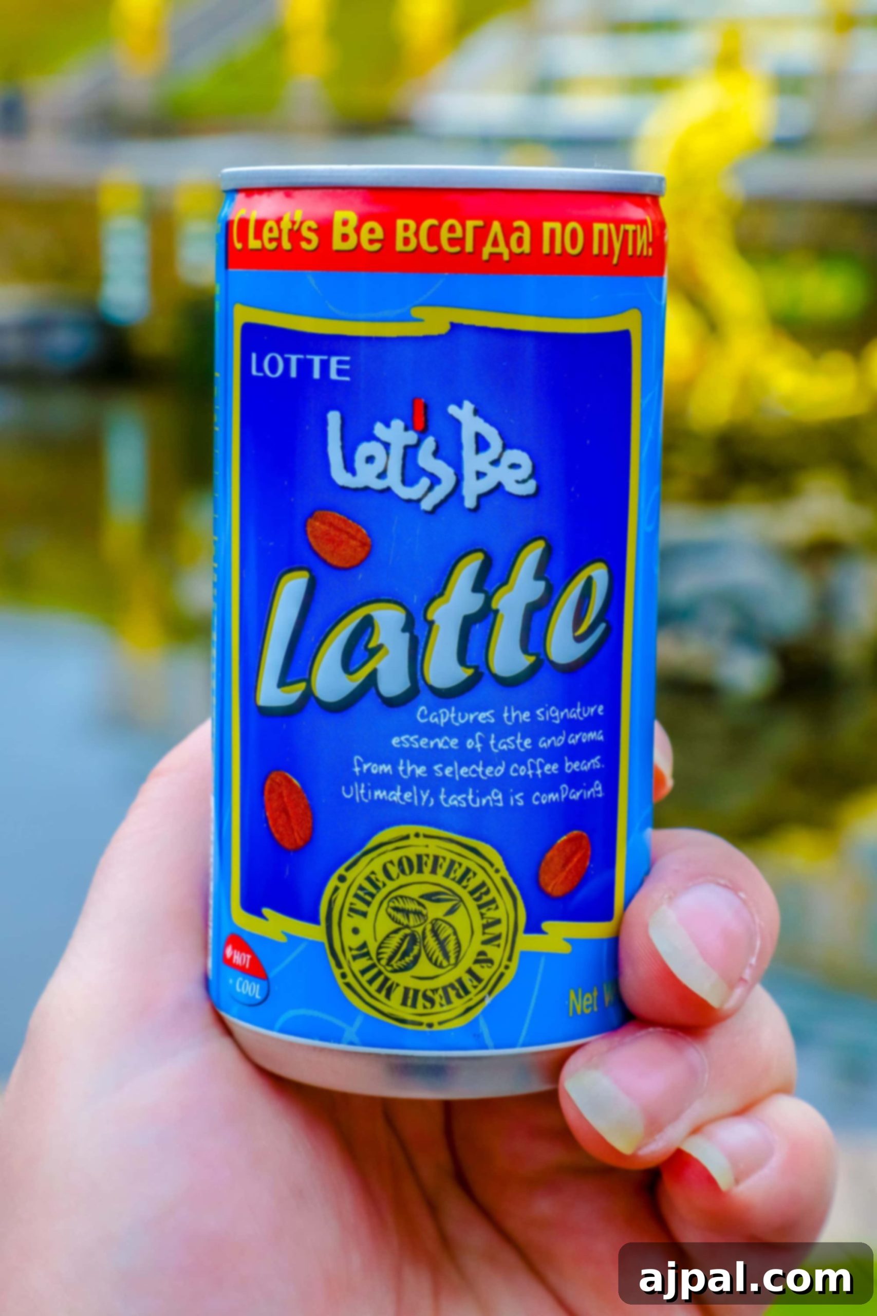 A person holding a canned latte, a simple refreshment enjoyed at Peterhof Palace in Russia.