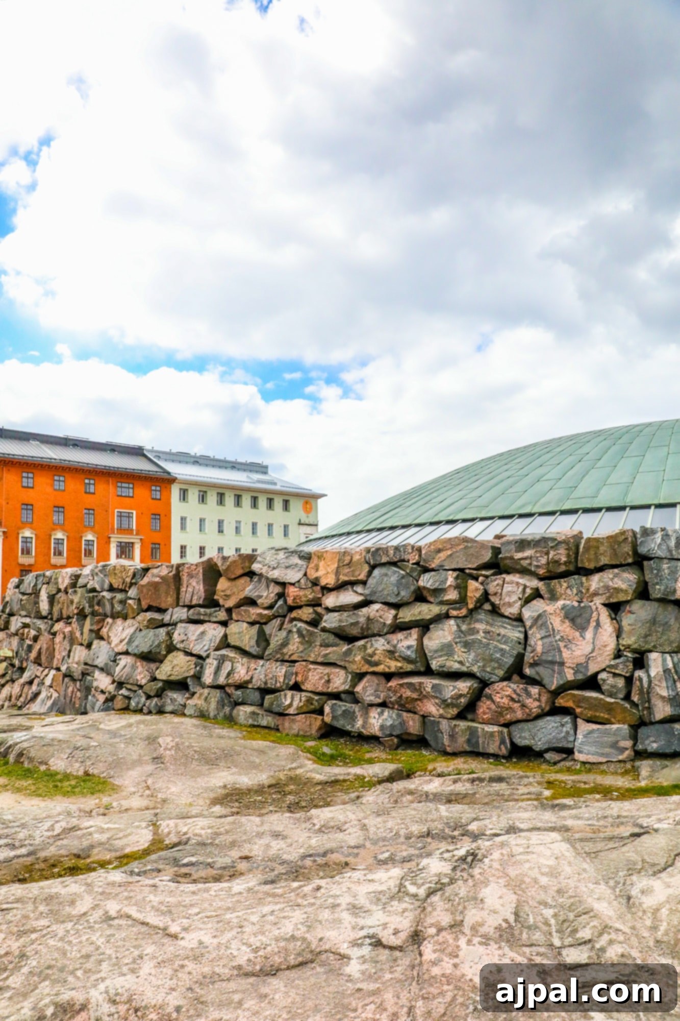 Temppeliaukio Church, also known as the Rock Church, stands majestically under a cloudy Helsinki sky.