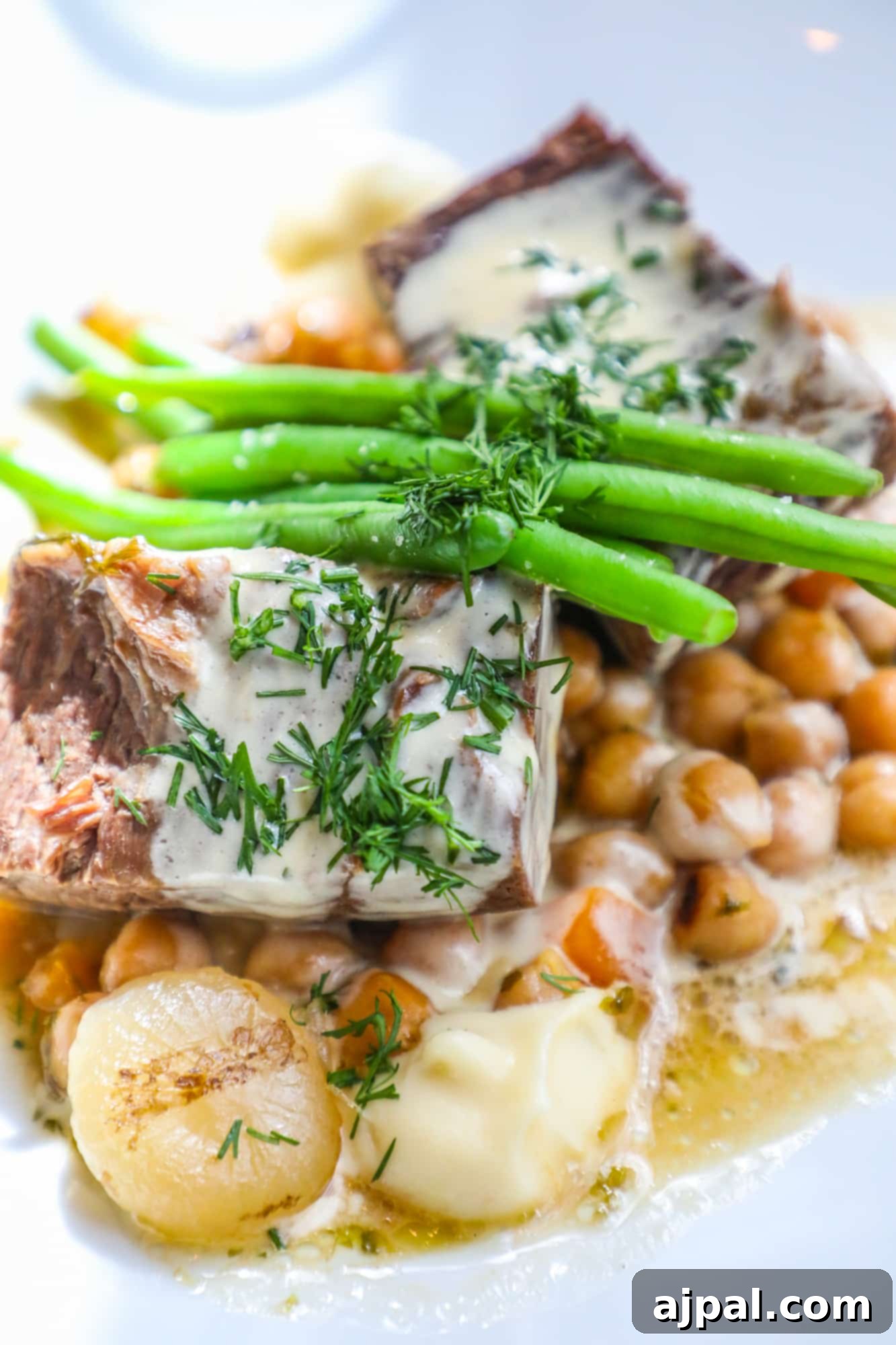 A savory pot roast with a creamy dill and asparagus sauce, served over chickpeas, a highlight at Kappeli.