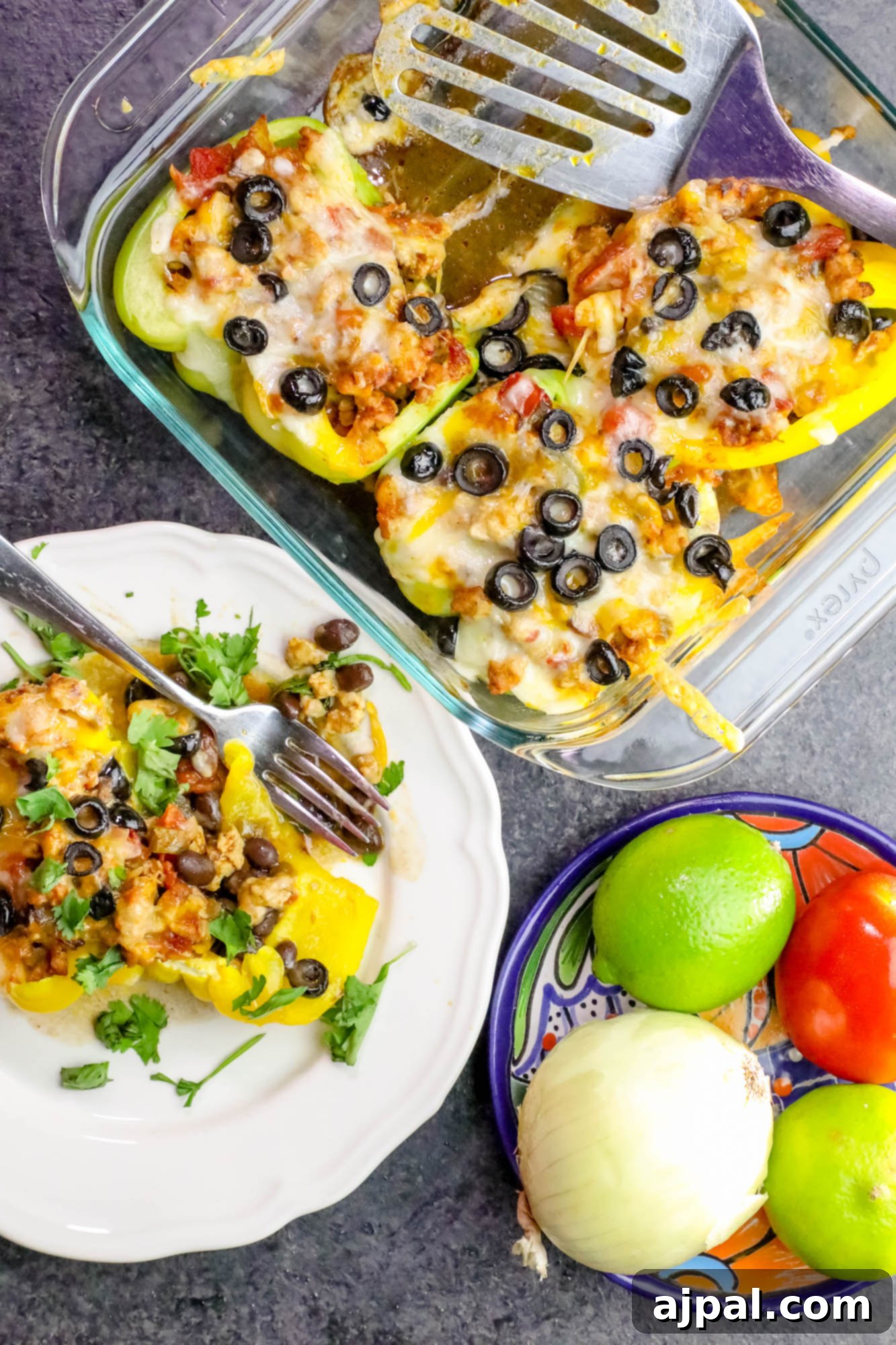 Beautifully arranged chicken taco stuffed peppers in a casserole dish, topped with melted cheddar cheese and black olives, showcasing a healthy and delicious meal.