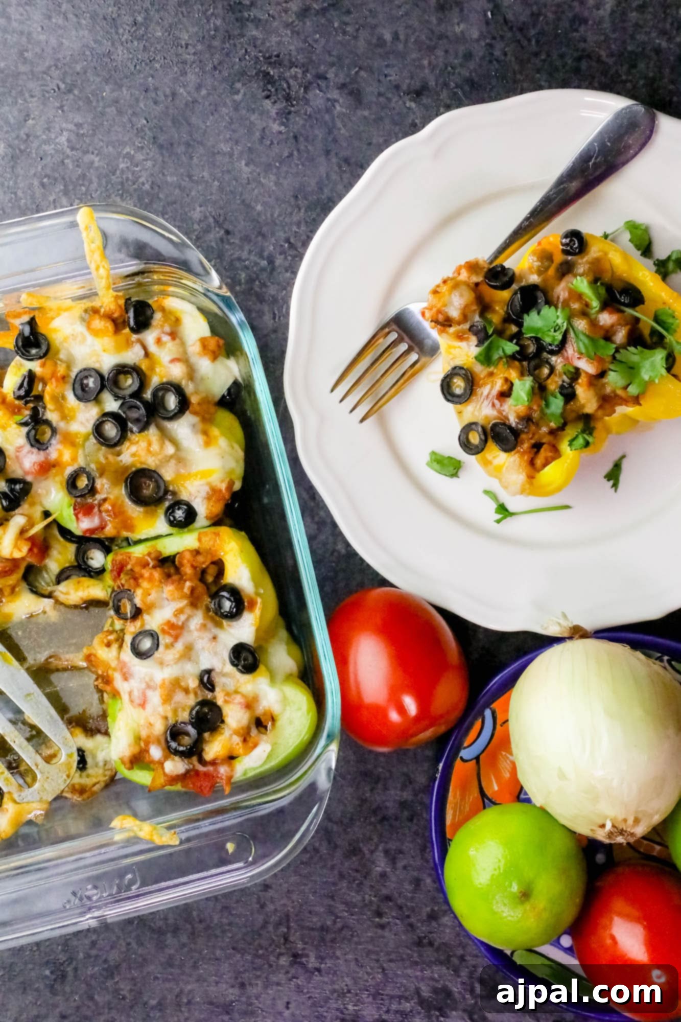 Close-up of cheesy chicken taco stuffed peppers in a glass casserole dish, with visible black olives on top, prior to baking.