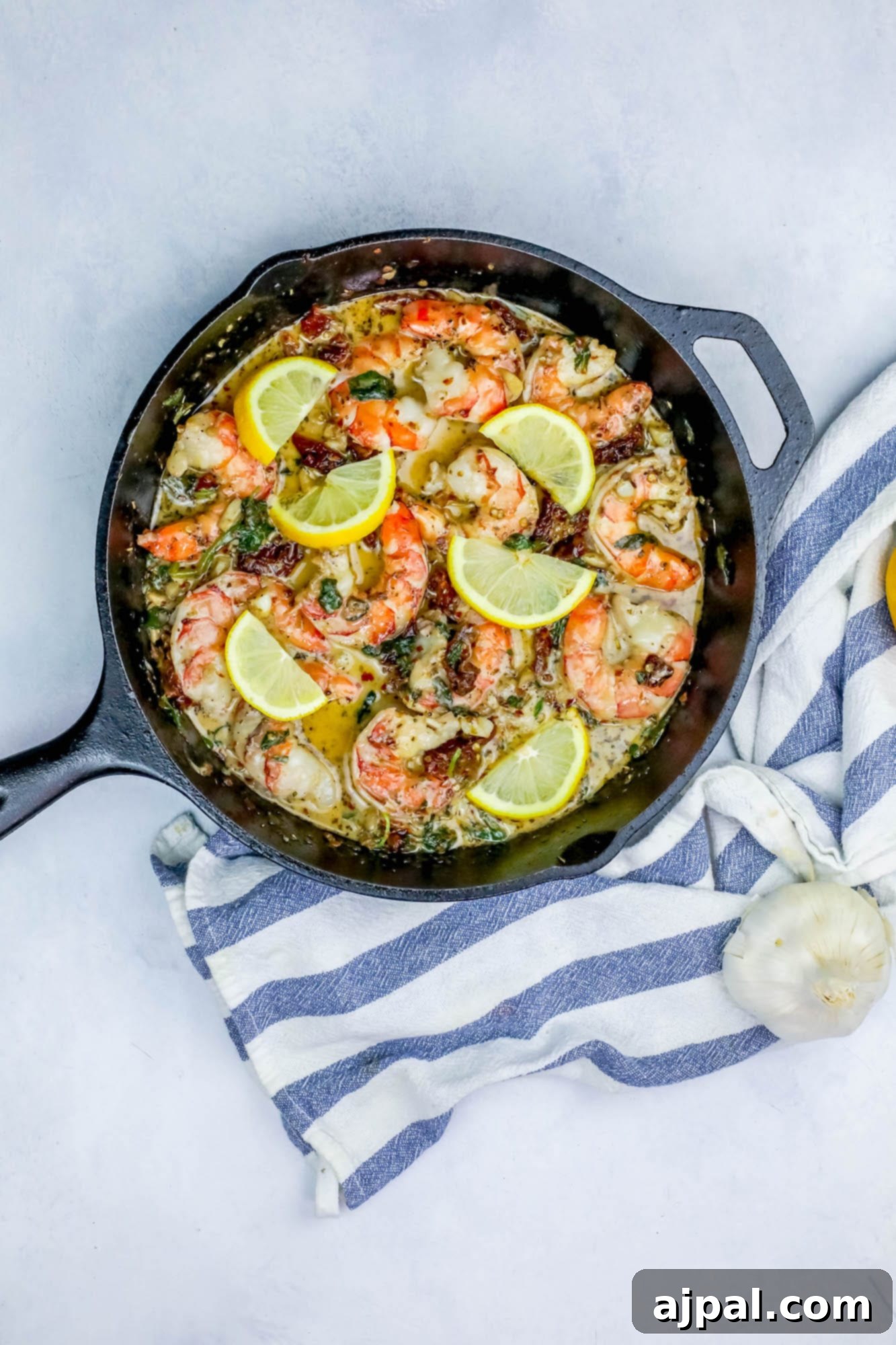 A vibrant creamy shrimp skillet, perfectly cooked, garnished with fresh lemon wedges.