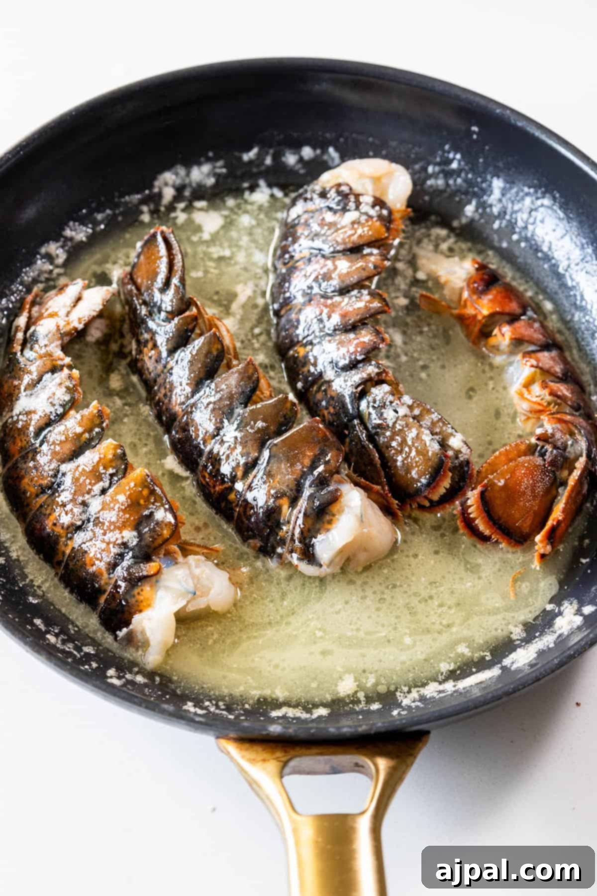 Decadent Butter Poached Lobster Tails 4 Lobster tails simmering gently in a flavorful butter and garlic sauce.