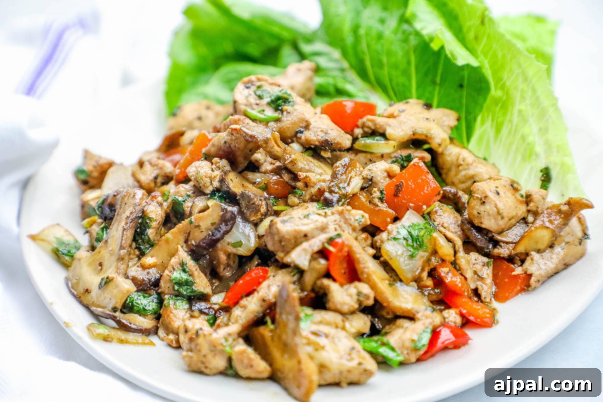 Diced pork lettuce cups with ranch seasonings, elegantly arranged on a white plate, ready to be enjoyed.