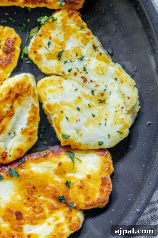 Greek Pan Fried Halloumi Recipe 10 Slices of halloumi cheese sizzling and browning in a hot pan, showing the cooking process of this delicious Greek cheese.