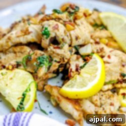 Grilled chicken tenders with lemon slices on a plate, ready to be enjoyed.