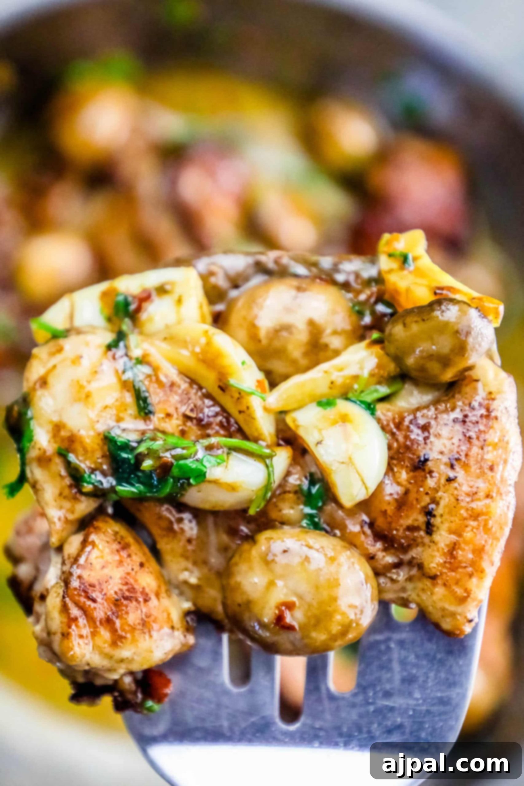 Quick One Pot Garlic Butter Chicken Thighs and Mushrooms 3 A serving of garlic butter chicken and mushrooms on a spatula, showcasing the tender meat and rich sauce.