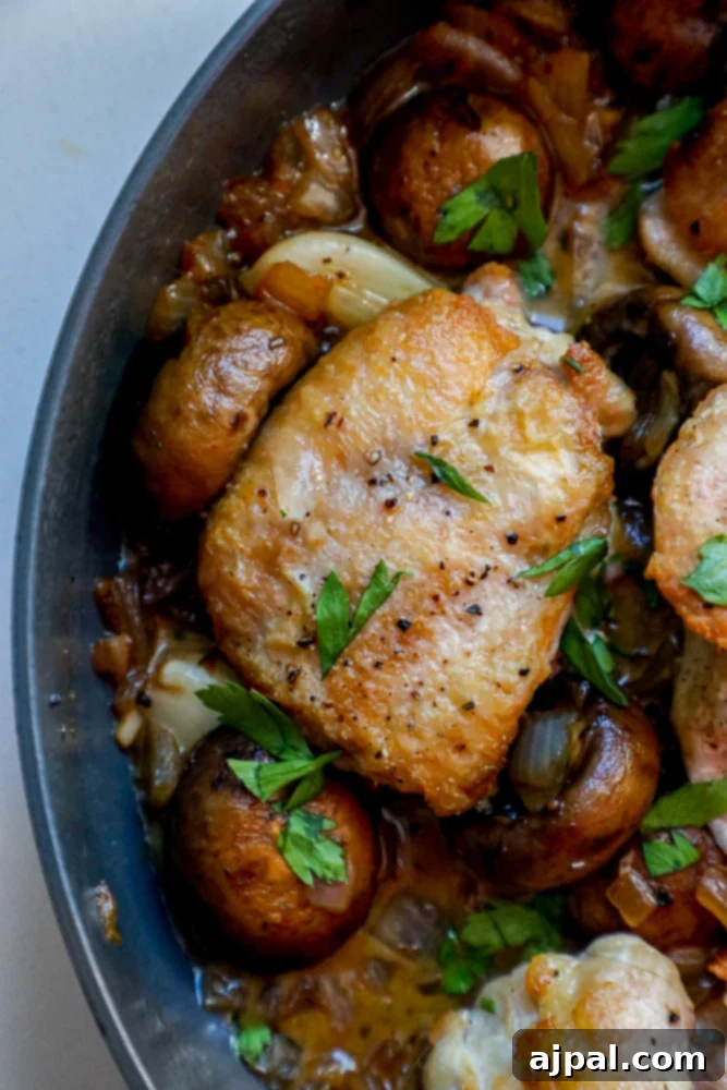 Quick One Pot Garlic Butter Chicken Thighs and Mushrooms 5 Perfectly pan-fried chicken thighs and sautéed mushrooms bathed in a rich garlic butter sauce, ready for serving from the pan.
