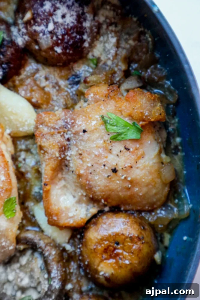 Quick One Pot Garlic Butter Chicken Thighs and Mushrooms 7 A vibrant serving of garlic butter chicken thighs and mushrooms in a blue bowl, garnished with fresh herbs.