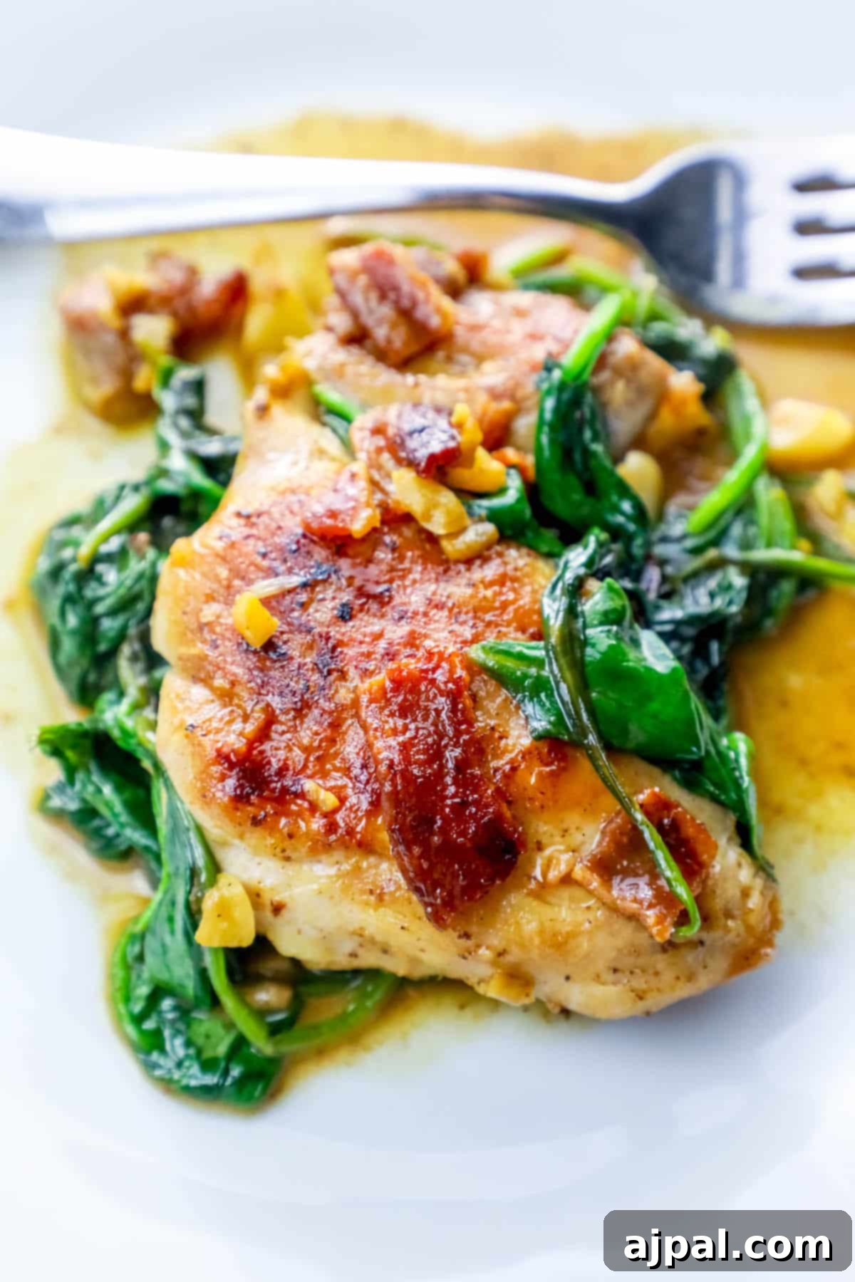 Easy Skillet Bacon Garlic Chicken and Spinach 2 Delicious one-pot chicken dinner with crispy bacon and fresh spinach, served on a white plate.