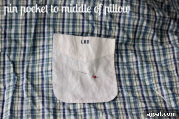 A close-up view of a shirt pocket pinned onto a square of fabric, ready to be stitched down, a crucial step in making a Daddy's Shirt Pillow.
