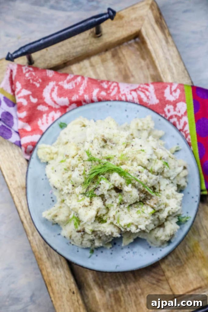 Deliciously creamy mashed potatoes in a bowl, garnished generously with fresh dill, ready to be served.