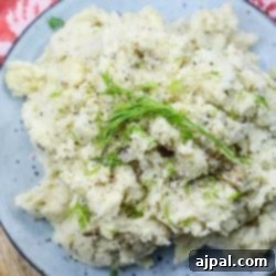 Instant Pot mashed potatoes with fresh dill sprinkled on top, showcasing a creamy texture.