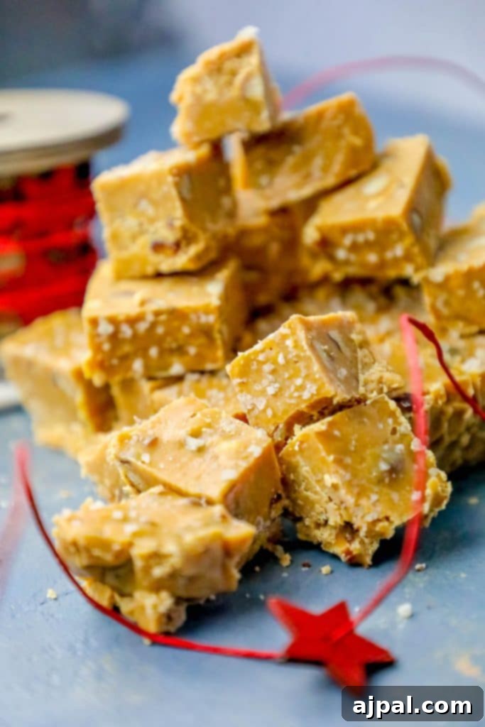 Luscious Butterscotch Walnut Slow Cooker Fudge 3 A generous stack of homemade Slow Cooker Butterscotch Fudge squares, studded with walnuts, presented beautifully on a rustic blue table.