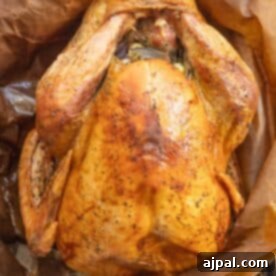 Flavorful Herb Roasted Turkey in a Bag 14 Roasted whole turkey on brown parchment paper, seasoned and cooked using the Brown Bag Herb Roasted Turkey Recipe to achieve a perfect golden-brown hue.