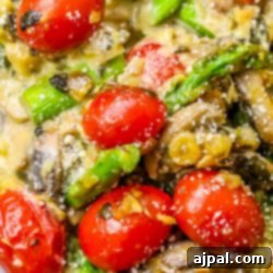 A close up of mushrooms and tomatoes in a white bowl.