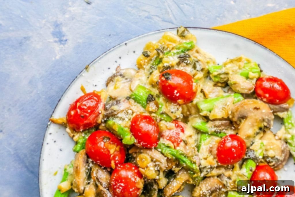 A plate featuring mushrooms and tomatoes topped with creamy spinach and artichoke dip.