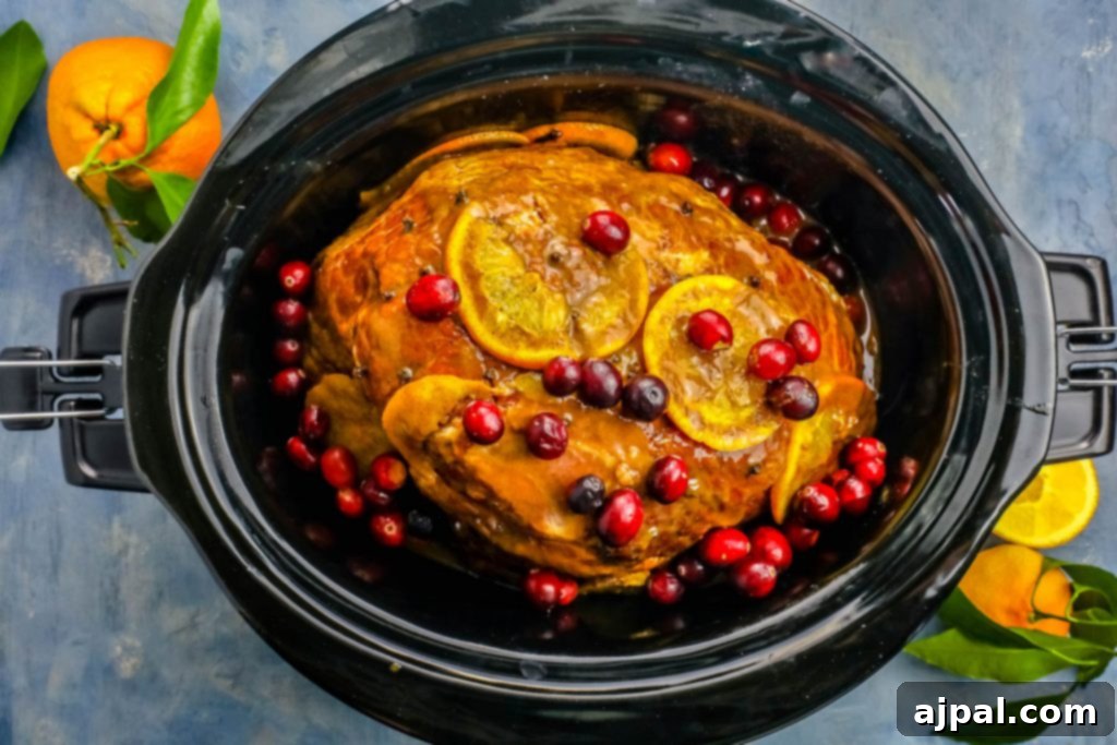 Slow Cooker Ham with Zesty Orange Cranberry Ginger Glaze 5 A generous slice of slow cooker orange cranberry ginger glazed ham on a serving platter, ready to be enjoyed.