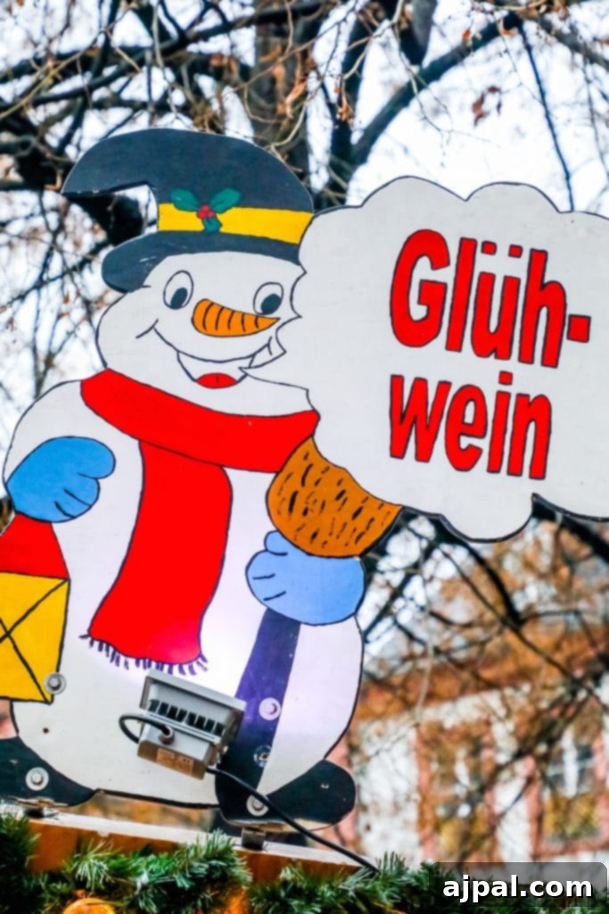 A snowman figure holding a 'Glühwein' sign at a German Christmas market, embodying festive cheer