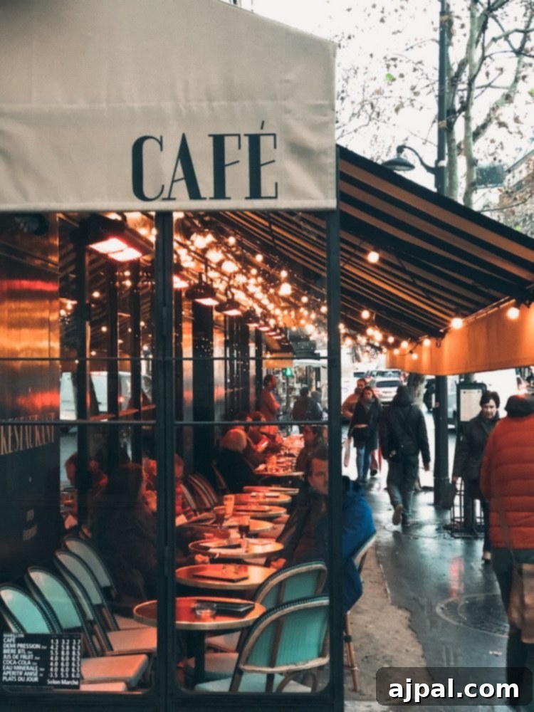 A charming Parisian cafe decorated for Christmas, with people enjoying a warm drink on a rainy day