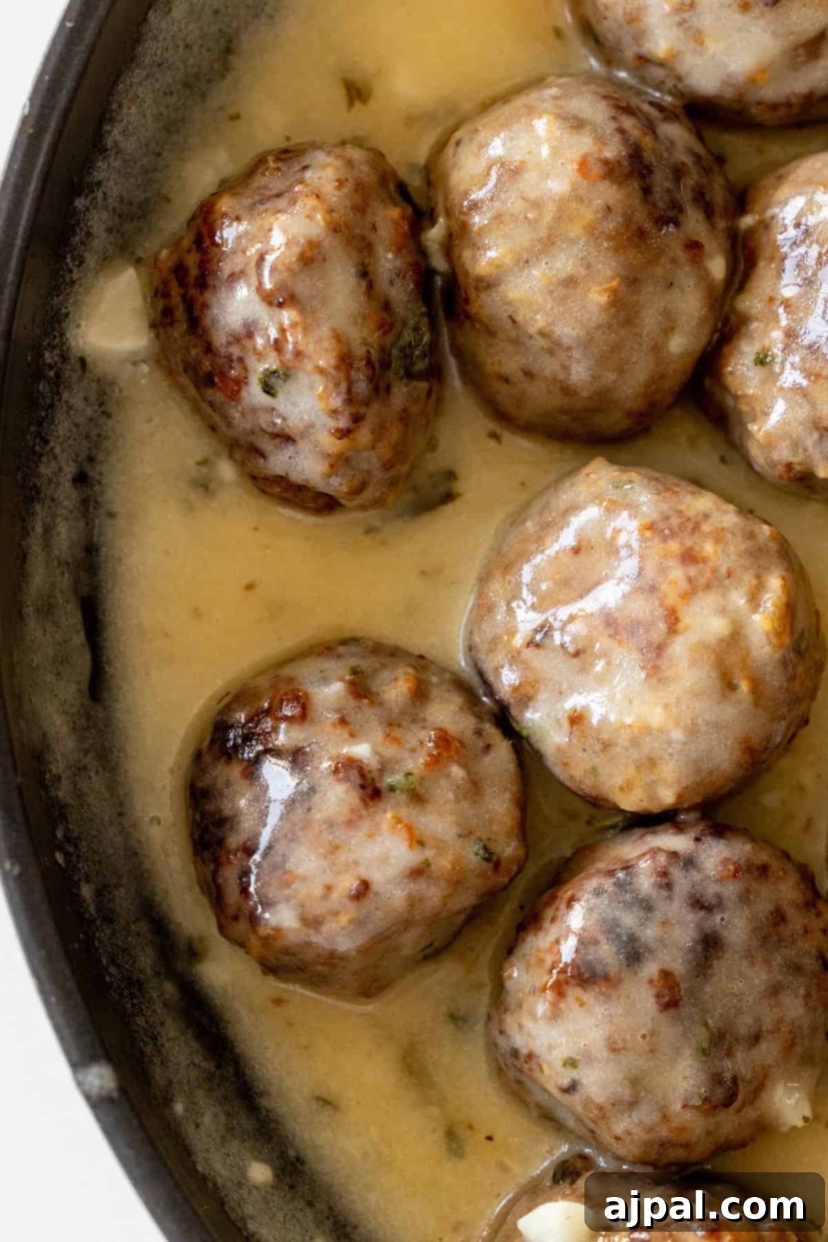 A close-up of One Pot Garlic Meatballs simmering in a creamy sauce within a skillet, showcasing a perfect easy keto diet dinner.