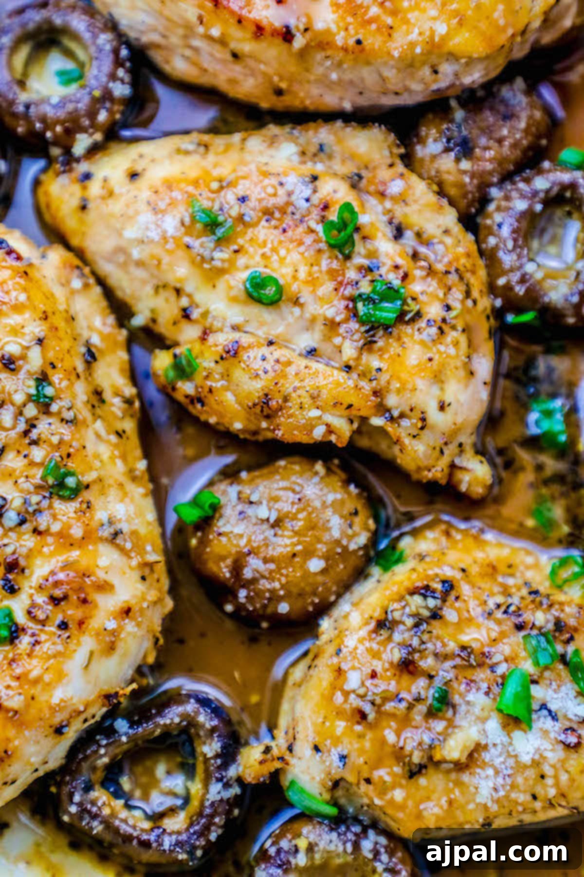 Pan-Seared Garlic Parmesan Chicken and Mushrooms 4 Savory garlic Parmesan chicken breasts with mushrooms, perfectly cooked in a pan and garnished with fresh green onions.