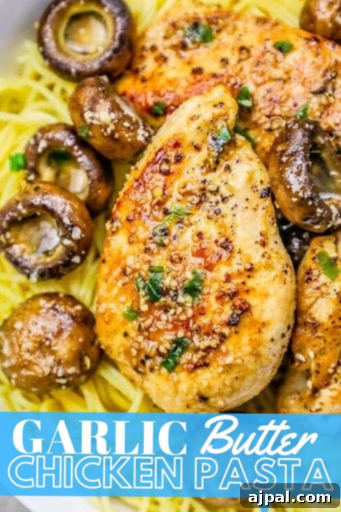 Close-up picture of garlic butter chicken pasta with mushrooms on a plate, garnished with fresh parsley.