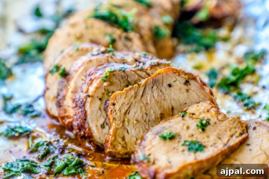 Your New Favorite Baked Pork Tenderloin 2 Picture of pork tenderloin sliced and garnished with parsley on tinfoil.