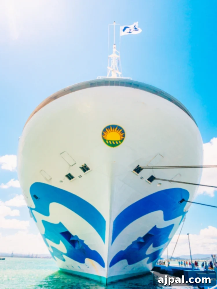 A majestic blue cruise ship, adorned with vibrant flags, gracefully docked in the crystal-clear waters of a Caribbean port, embodying the spirit of relaxed travel.