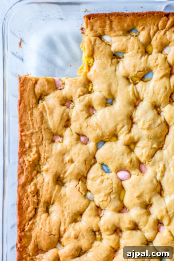Deliciously moist blondies with Cadbury Mini Eggs, presented in a glass baking dish, waiting to be served.