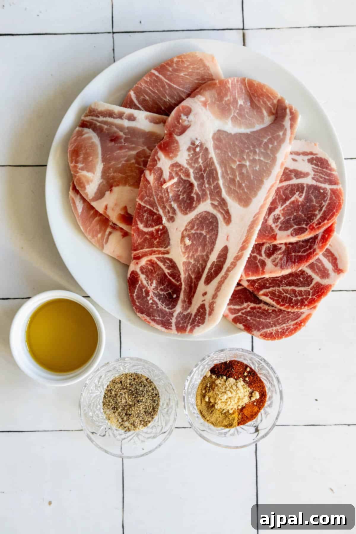 Fall-Apart Tender Crock Pot Pork Steaks 6 A plate of meat and condiments on a tiled floor.