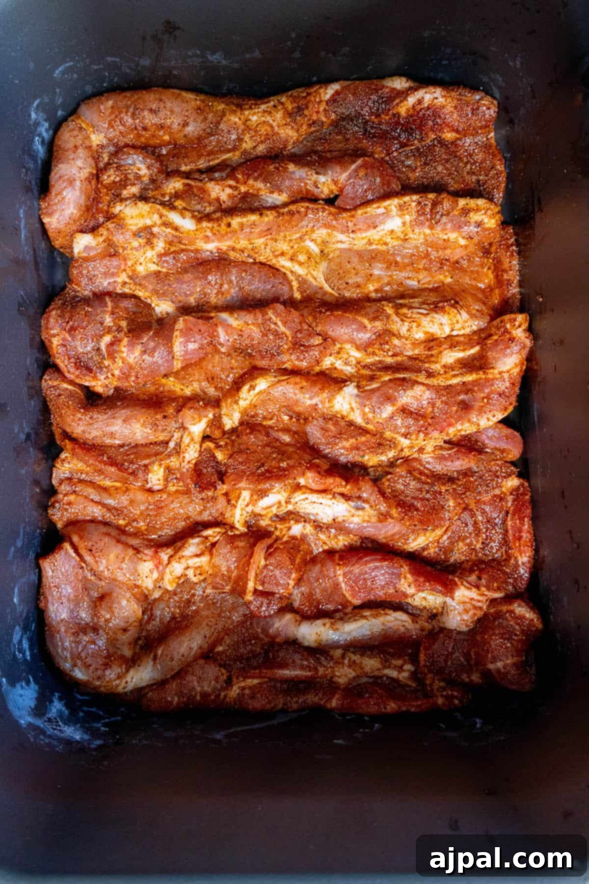 Fall-Apart Tender Crock Pot Pork Steaks 8 Easy Slow Cooker Pork Steaks Recipe in a baking pan.